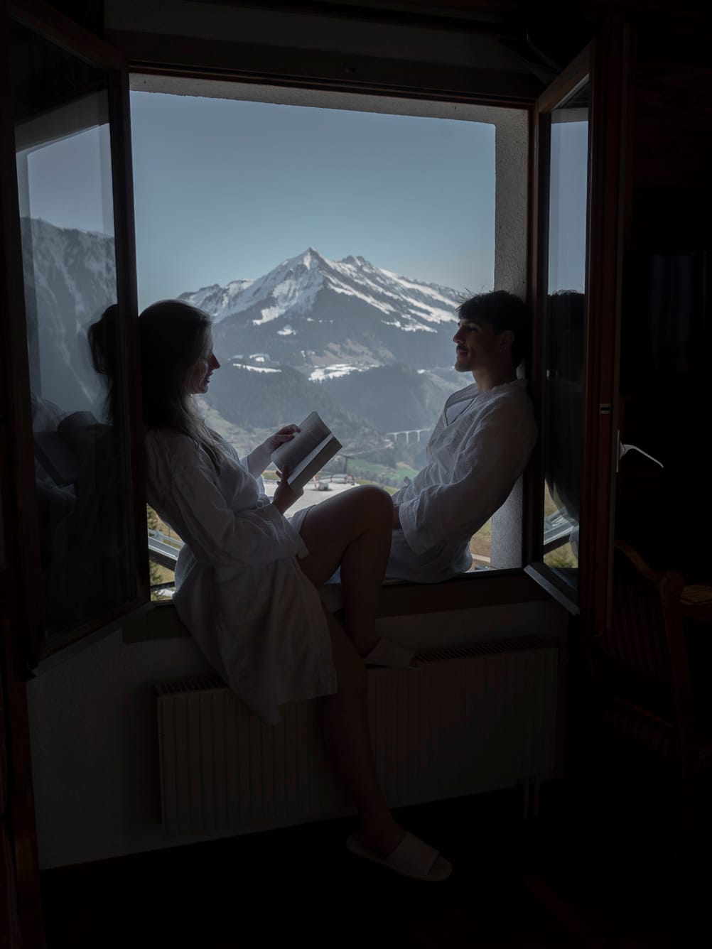 Lecture sur le rebord de la fenêtre face aux Alpes