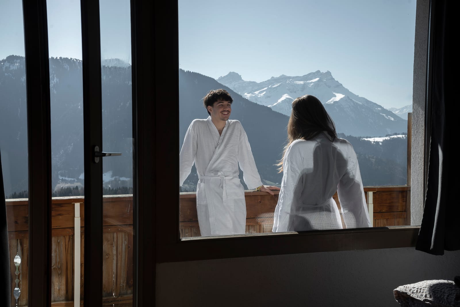 Échange en peignoirs sur le balcon avec vue alpine