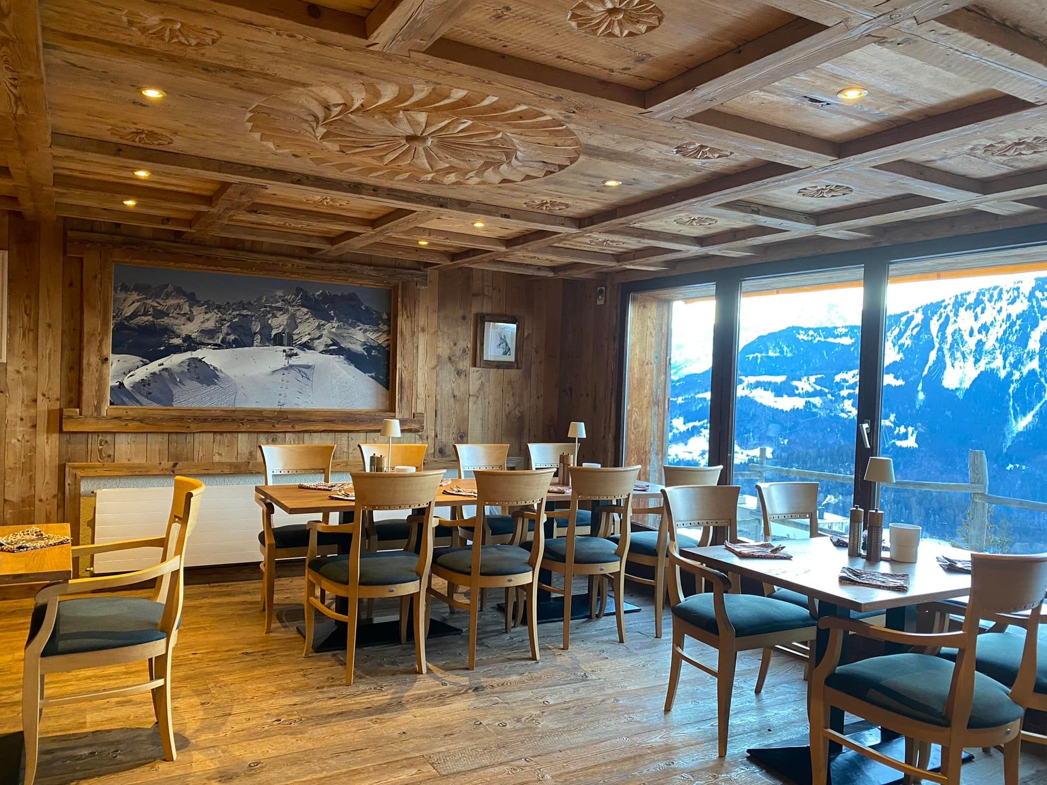 Salle de restaurant en bois aux lumières chaudes, vue sur la montagne